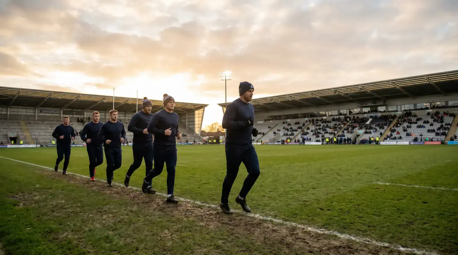 Substitutes warming up on a sideline in plain dark training kit