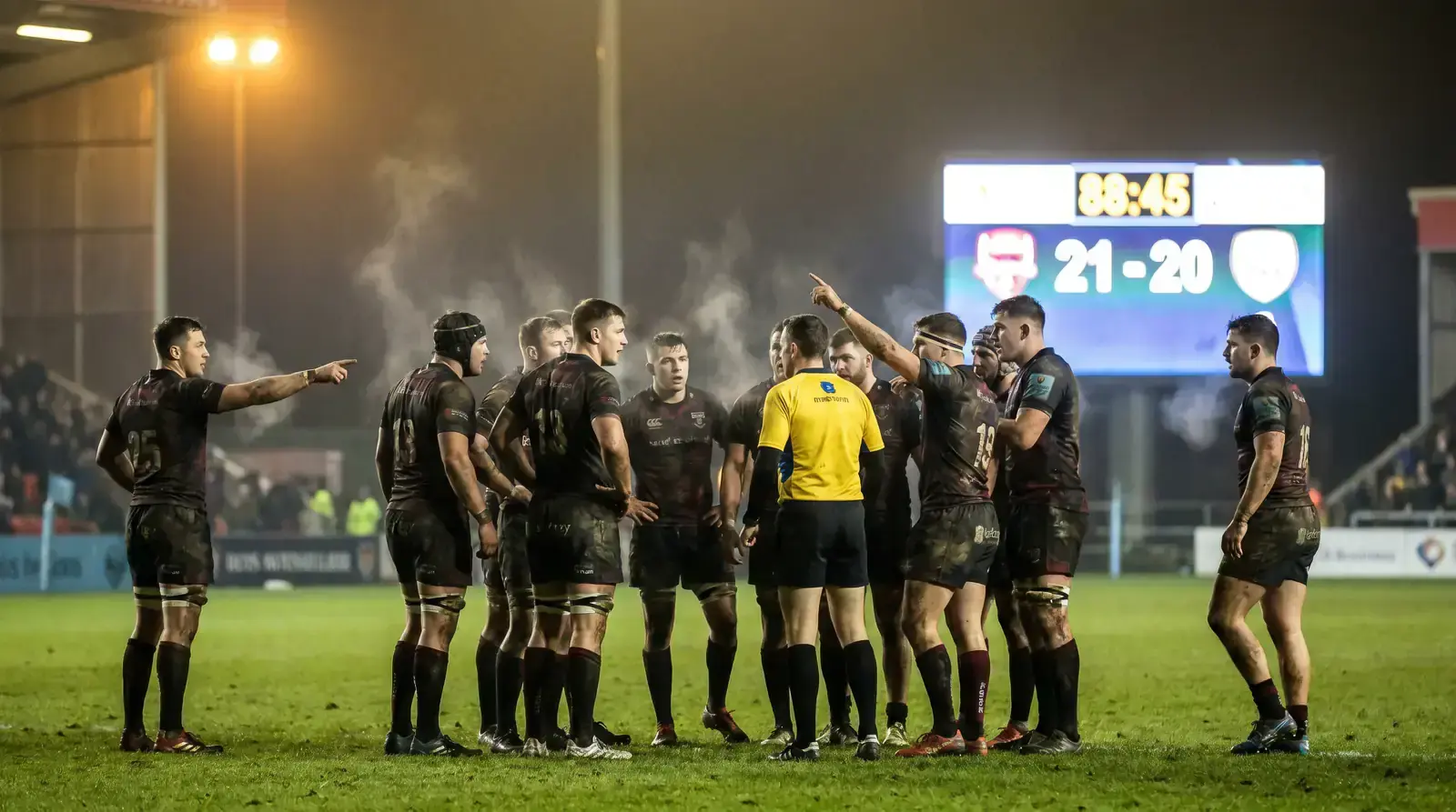Tense final minutes of a knockout rugby match with players and a referee close together