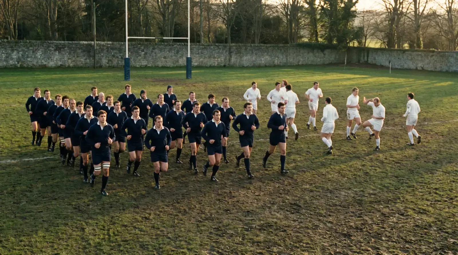 Two rugby teams of clearly different stature warming up on the same pitch