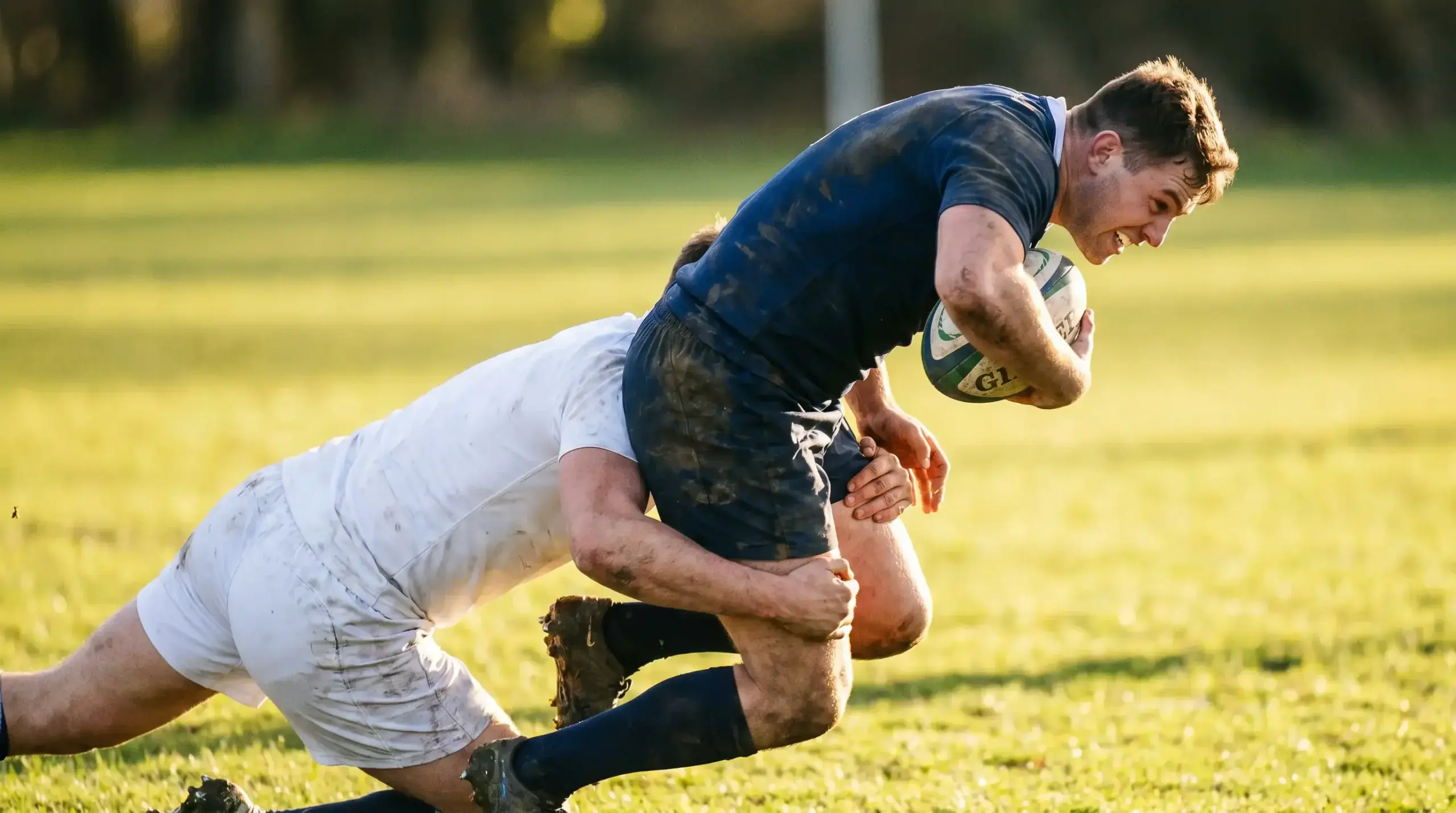 Two rugby players from contrasting kits in a tackle during a pool-stage match