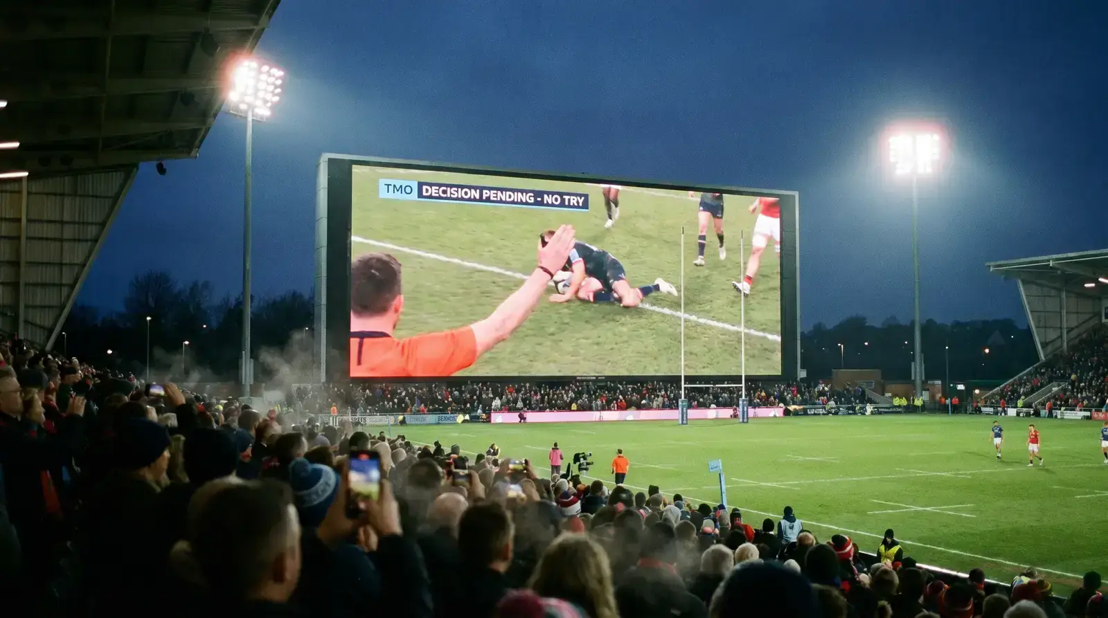 Large stadium screen showing a TMO replay during a rugby match